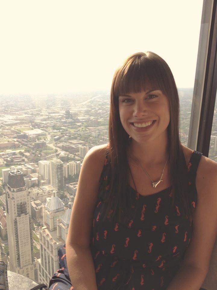 Anne-Marie smiling in front of a city skyline view